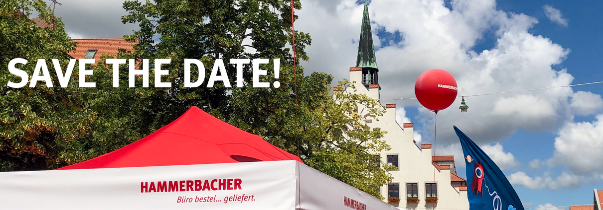 Ein rotes Zeltdach mit dem Logo der Hammerbacher GmBH, im Hintergrund ein Baum, ein roter Luftballon und das Neumarkter Rathaus